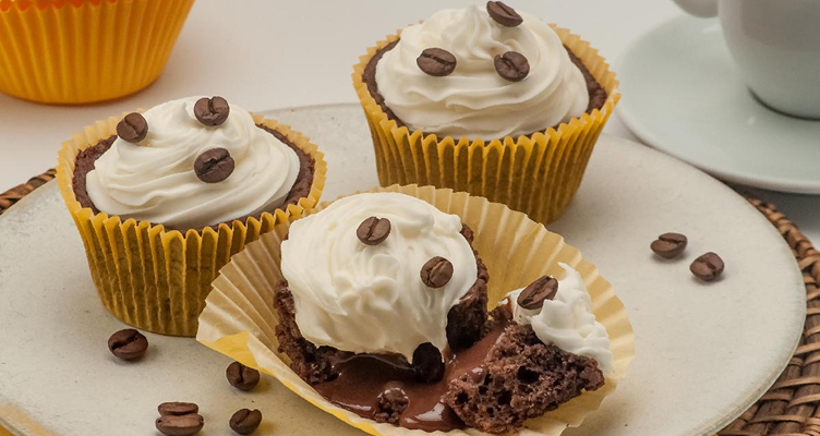 Imagem de um cupcake com grao s de cafe e um chantilly